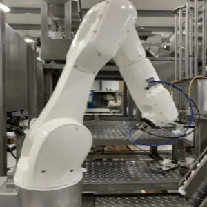 White KUKA robot operating in a stainless-steel food packaging system, designed for hygienic and efficient product handling in the food industry.